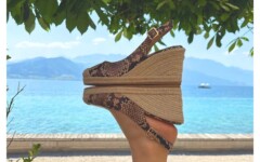Ženska noga u zmijolikoj sandali na platformi (espadrille) na pozadini jezera i planina