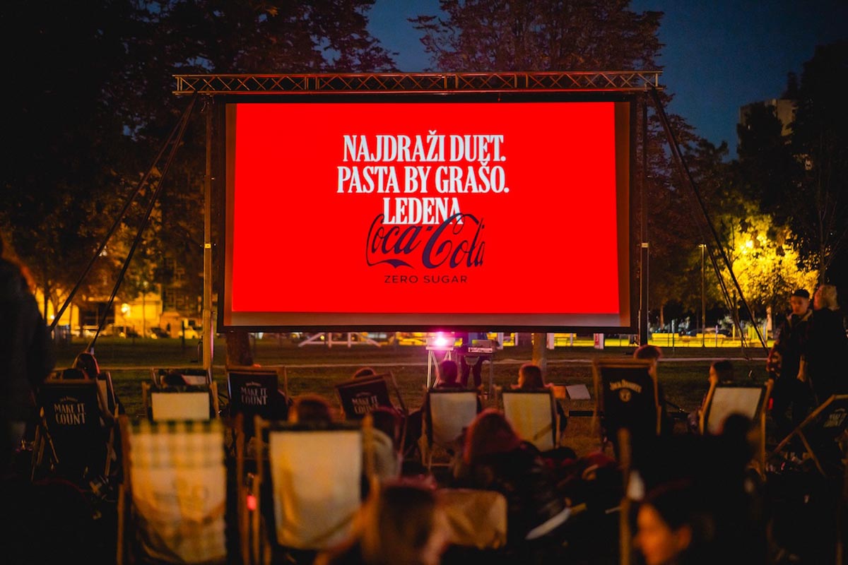 Reklama Pasta by Grašo i Coca-Cola na filmskom platnu Food Film Festivala pred publikom u parku.