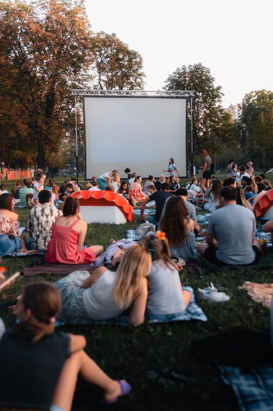 Kino na otvorenom u sklopu Food Film Festivala s posjetiteljima koji prate program s travnjaka.