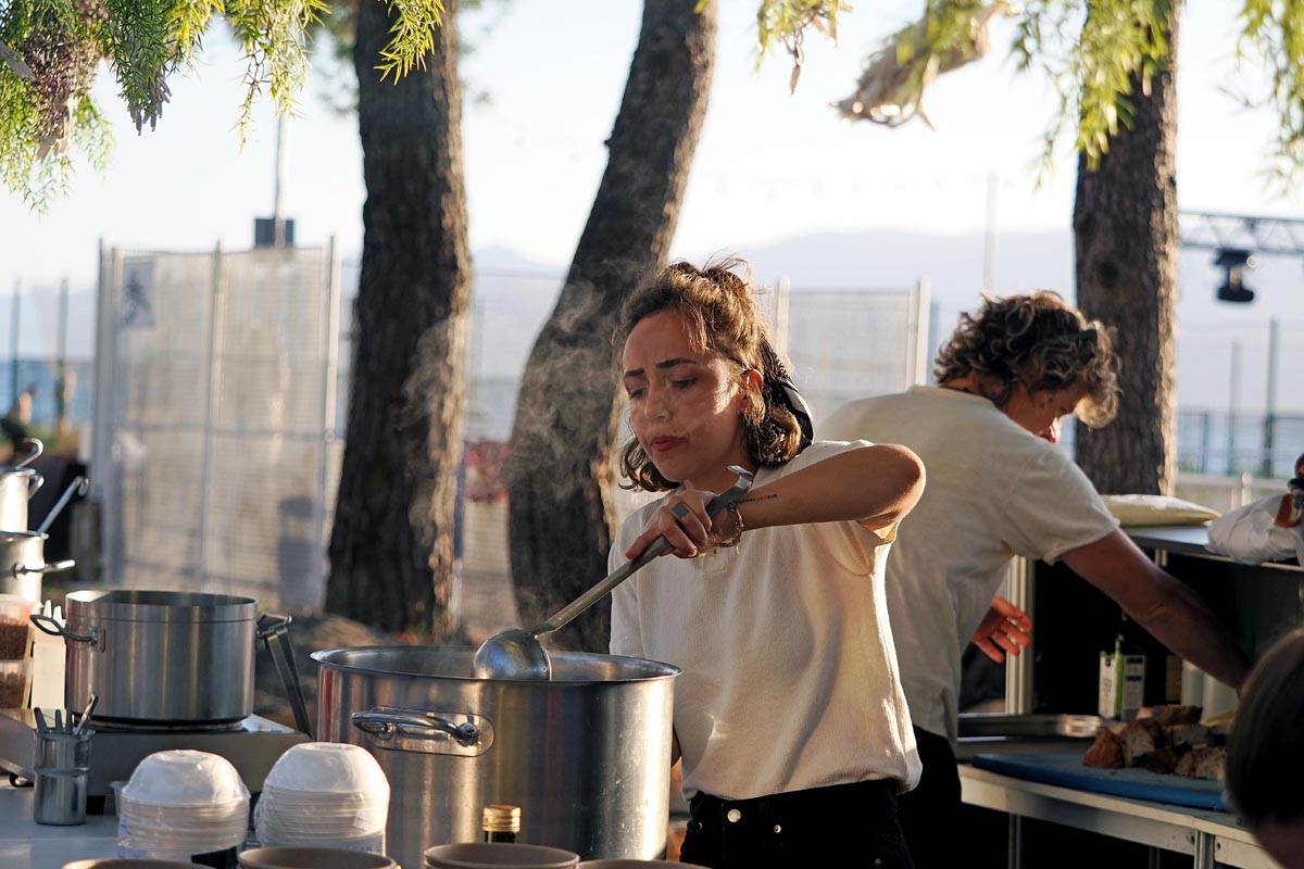 Katarina Vrenc (2) Katarina Vrenc priprema hranu na Porto Gastro Festivalu u Rijeci na otvorenom štandu pod drvećem.