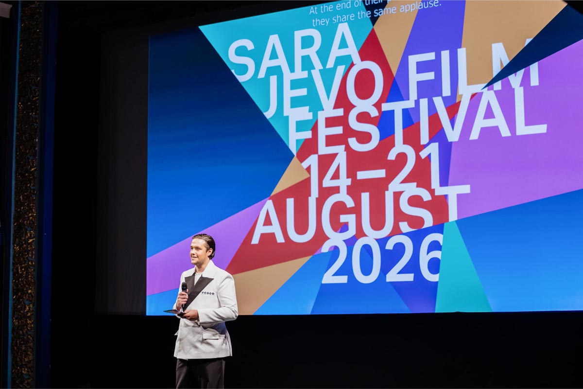 Voditelj Kerim Čutuna na pozornici Sarajevo Film Festivala 2026. drži govor ispred festivalskog platna.