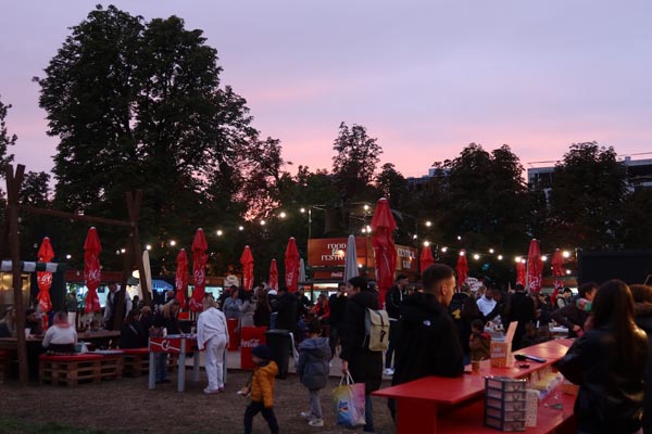 Posjetitelji na Food Film Festivalu u Zagrebu uživaju u street food ponudi u parku dr. Franje Tuđmana u sumrak.
