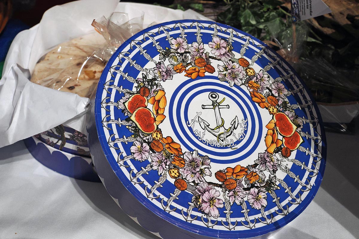kostrenska torta Okrugla plavo-bijela ukrasna kutija s motivom sidra, smokava i cvijeća za tradicijsku Kvarnersku tortu.