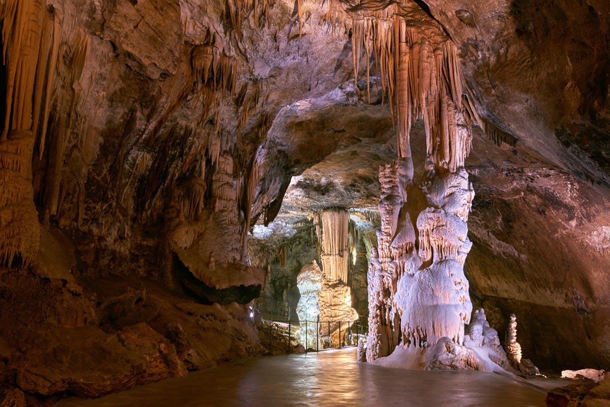 Raskošni stalaktiti i stalagmiti oko pješačke staze u unutrašnjosti Postojnske jame