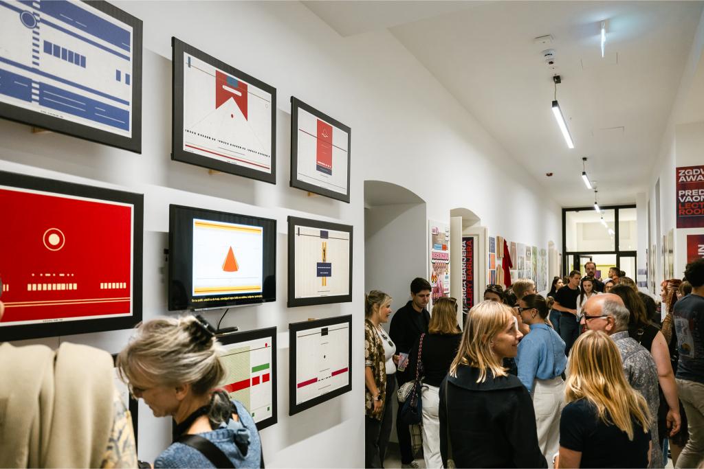 Posjetitelji promatraju uokvirene grafičke radove i ilustracije na zidu tijekom Zagreb Design Weeka