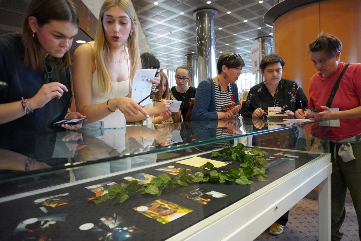 Sudionici escape room igre proučavaju tragove i rješavaju zagonetke oko staklene vitrine