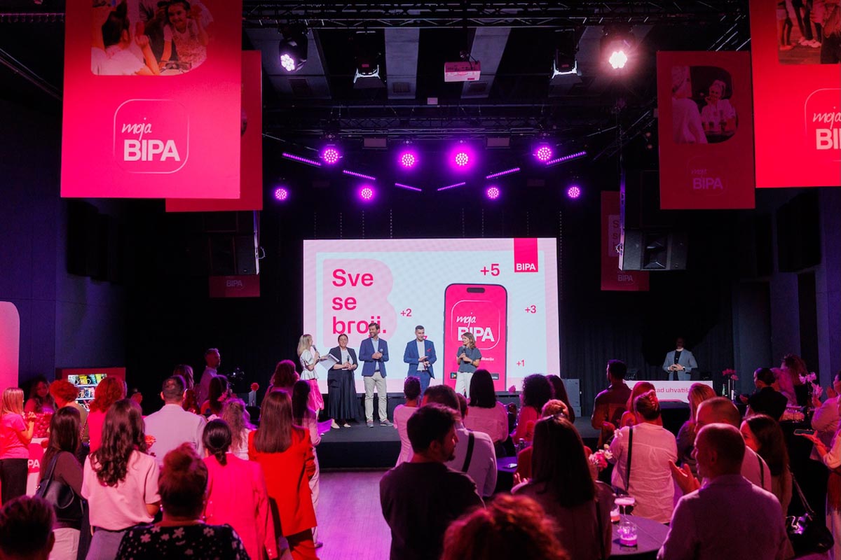 Predstavljanje novaBIPA aplikacije na pozornici pred publikom pod ružičastim svjetlima u dvorani konferencije