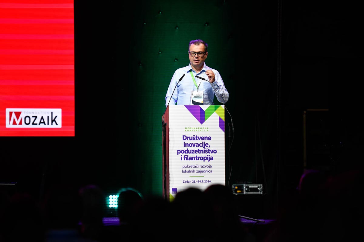 Govornik drži predavanje za pultom konferencije Društvene inovacije, poduzetništvo i filantropija