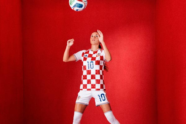 Hrvatska nogometašica Ana Bakalar u kockastom dresu s brojem deset udara loptu glavom