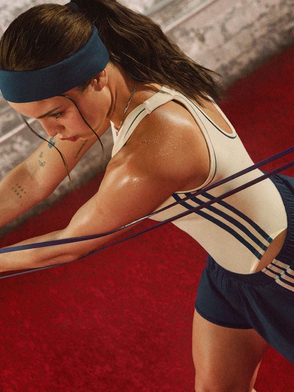 adidas-trening-elastična-traka-teretana Emilia Mernes u Adidas sportskoj odjeći izvodi trening s elastičnom trakom u teretani.