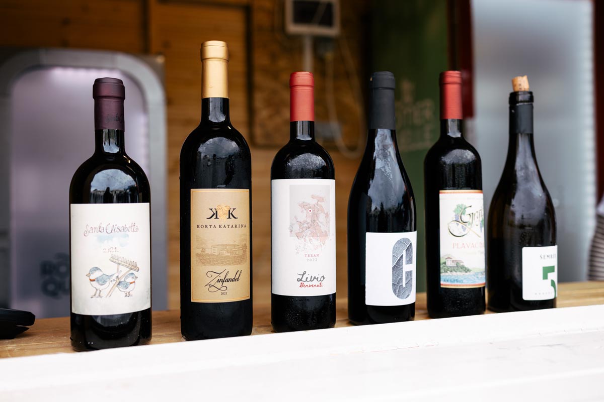Boce vrhunskog hrvatskog crnog i pjenušavog vina poredane na šanku