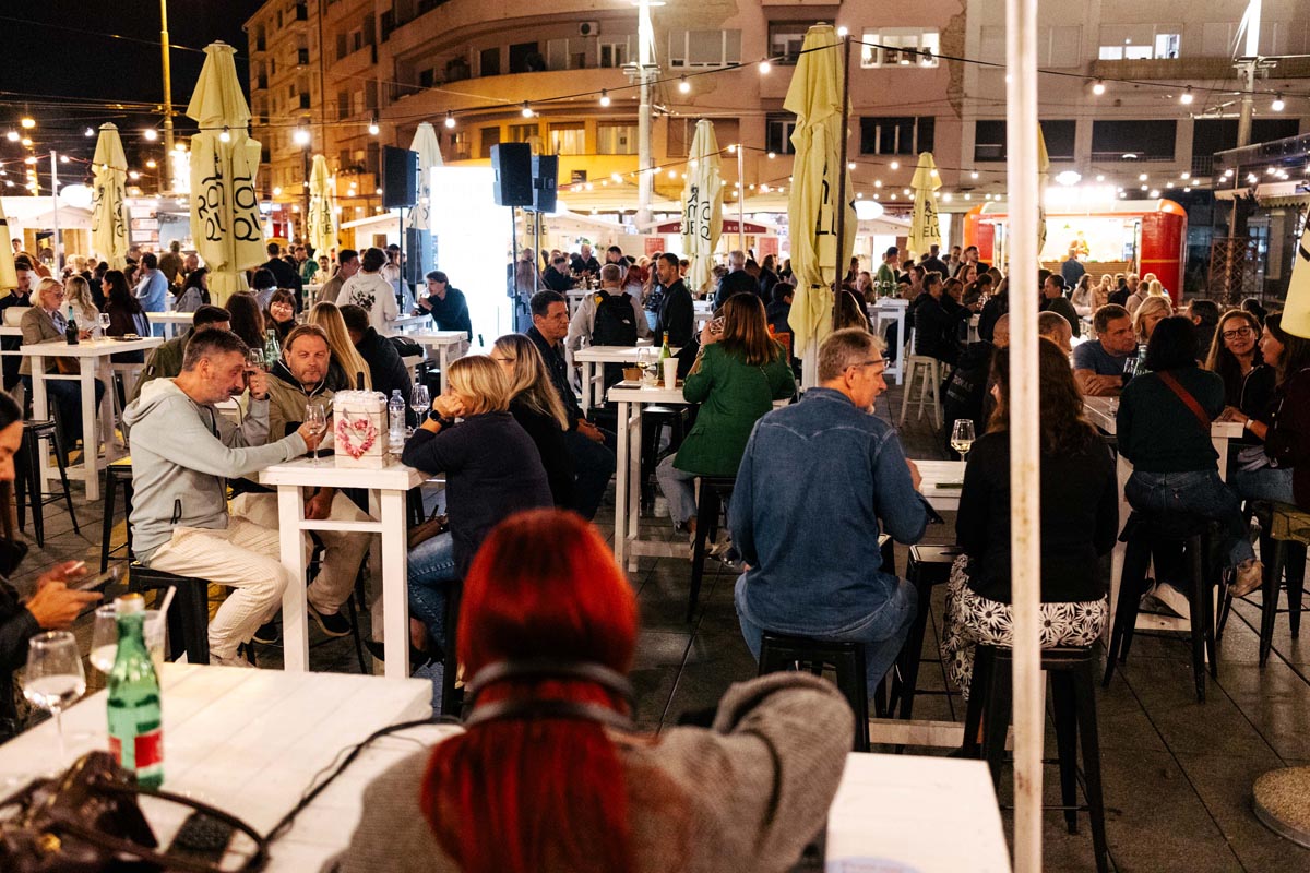 Posjetitelji sjede za visokim stolovima na Aftertaste festivalu hrane i pića