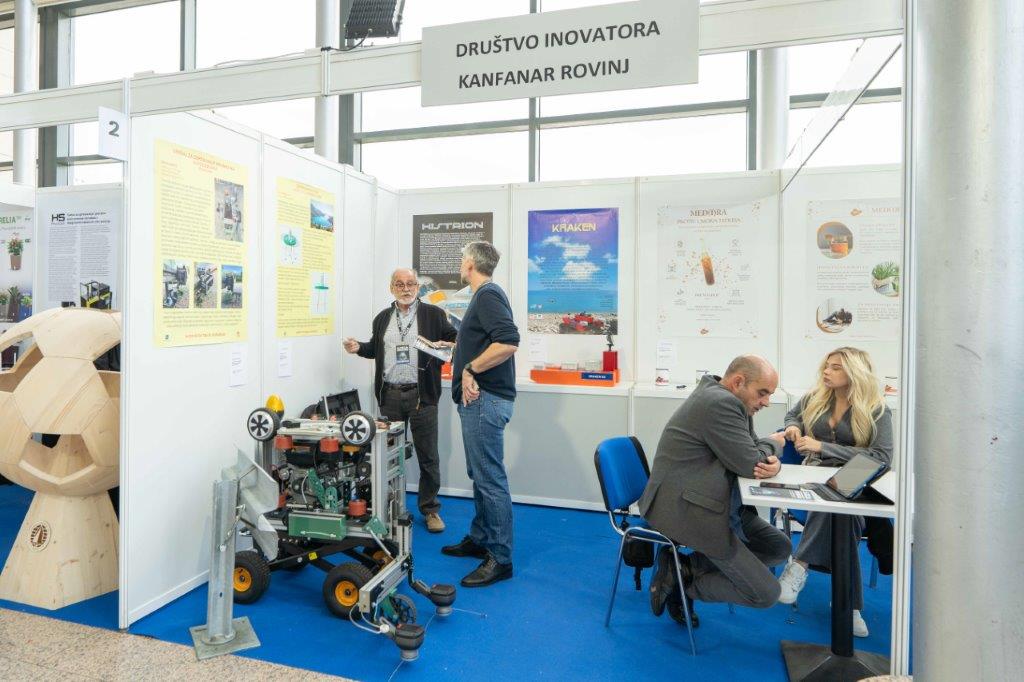 Izložbeni štand Društva inovatora Kanfanar Rovinj s robotiziranim vozilom i plakatima za projekte Histrion i Kraken