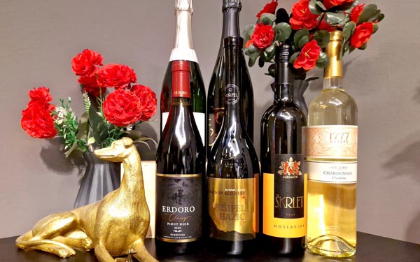 Boce vina Erdoro Pinot Noir, Pušipel Hažić, Škrlet Miklaužić i Chardonnay na crnom stolu