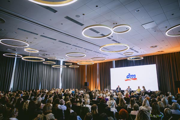 Velika dvorana puna posjetitelja na dm ženskoj konferenciji s panelistima na pozornici