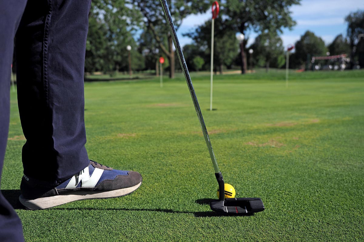 Igrač crnom palicom cilja žutu lopticu na zelenom golf igralištu u Moravskim Toplicama