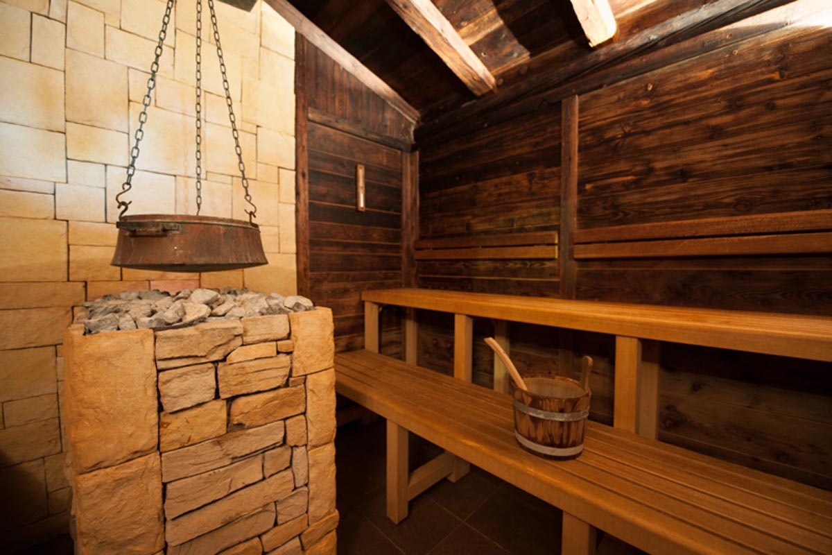 Tradicionalna drvena sauna s kamenom peći, visećim bakrenim kotlom i drvenim klupama