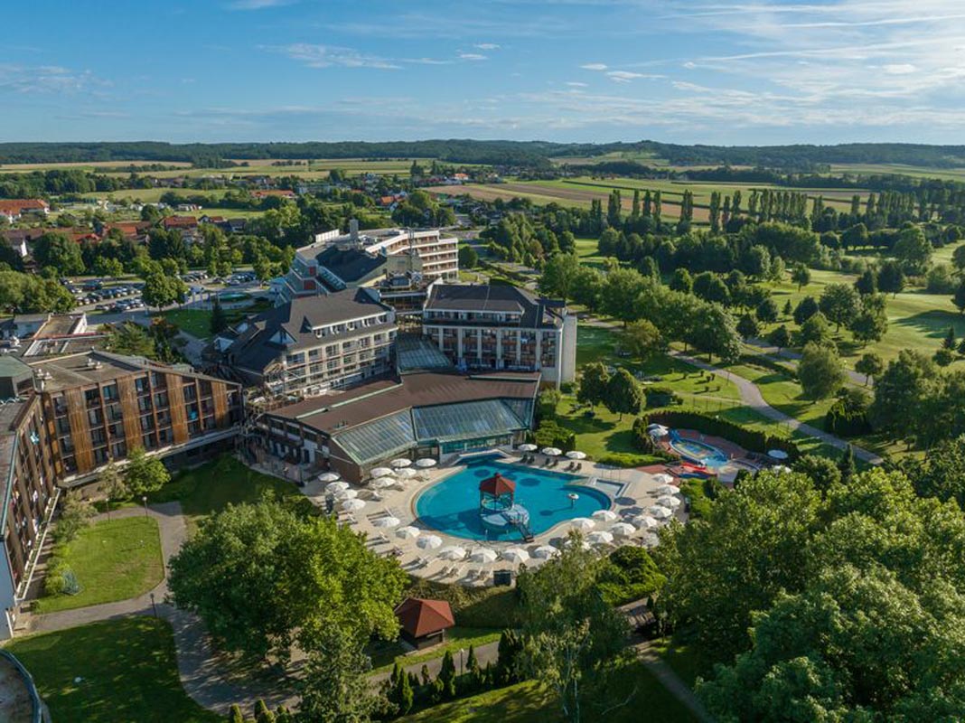 Pogled iz zraka na resort Terme 3000 s velikim kružnim bazenom, hotelima i golf igralištem