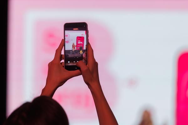 Ruke koje drže pametni telefon i fotografiraju prezentaciju na ekranu tijekom BIPA konferencije