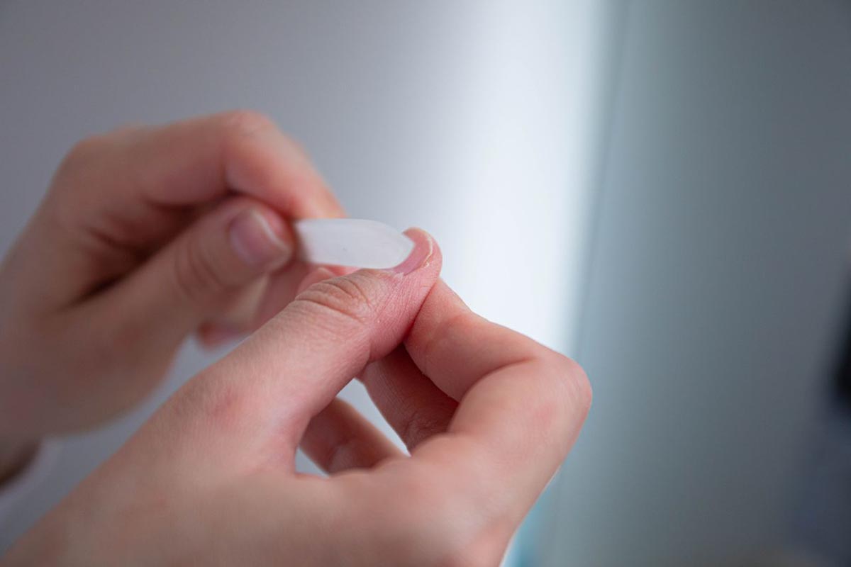 Krupni kadar ruku koje staklenom ili plastičnom rašpicom oblikuju nokat na palcu