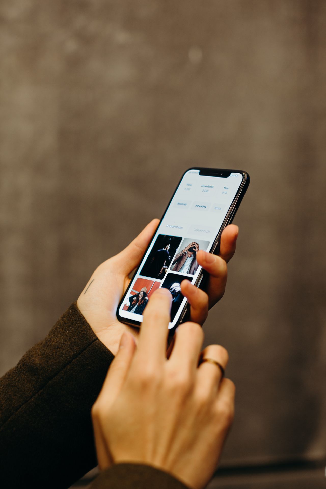 Ruke koje drže pametni telefon i pregledavaju galeriju slika na zaslonu