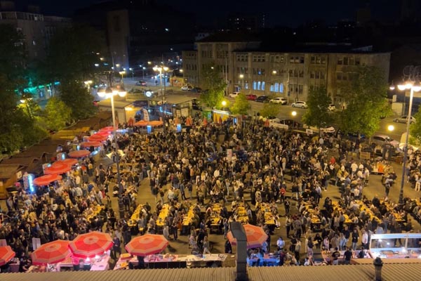 ljudi se zabavljaju i jedu navečer na place marketu na kvatriću