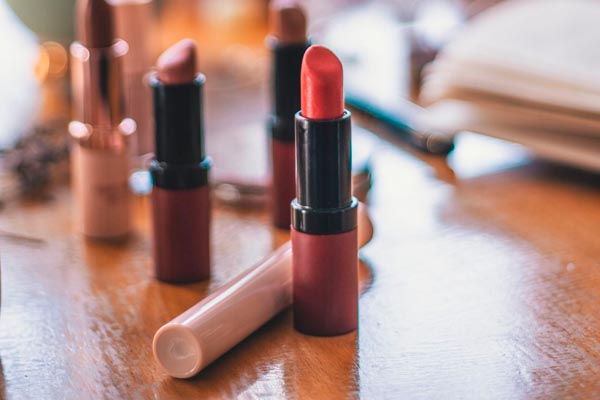 Crveni mat ruž za usne u prvom planu s nekoliko nude nijansi u pozadini