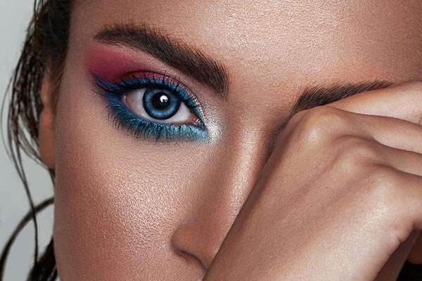 Urednički modni make-up look s odvažnim plavim i ružičastim sjenilom na modelu s plavim lećama