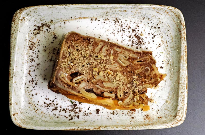 omad stonske torte s mljevenim orasima i čokoladnim prahom poslužen na rustikalnom keramičkom tanjuru, pogled odozgo.