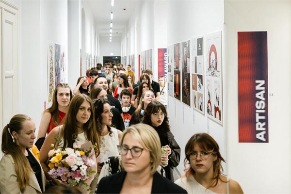 Posjetitelji razgledavaju izložene plakate u uskom i dugom hodniku izložbenog prostora Zagreb Design Weeka