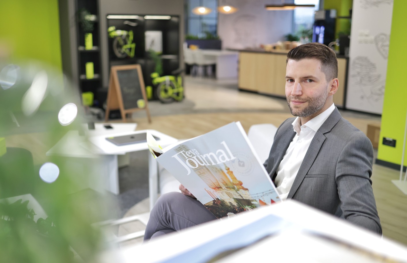 Branimir Zorko u sivom odijelu drži Teya Journal časopis u moderno uređenom uredu