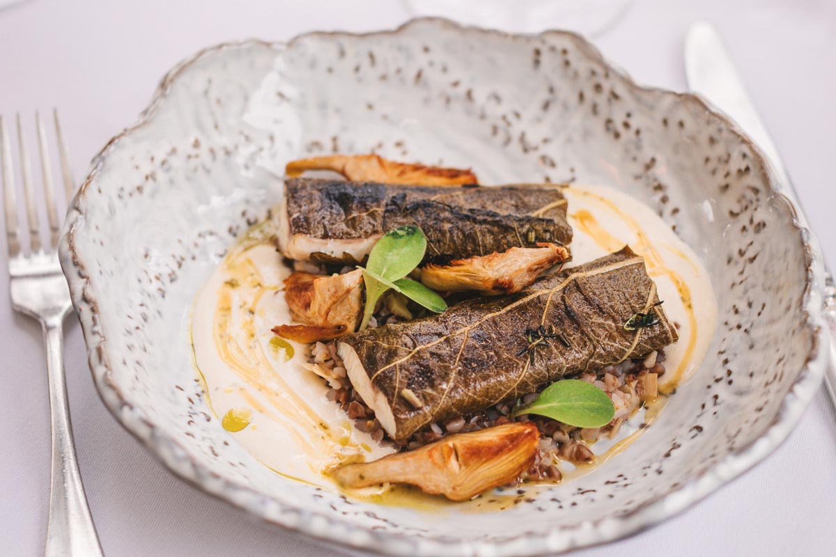 Filet ribe pečen u listu na podlozi od žitarica i umaka poslužen u Le Bistro Esplanade