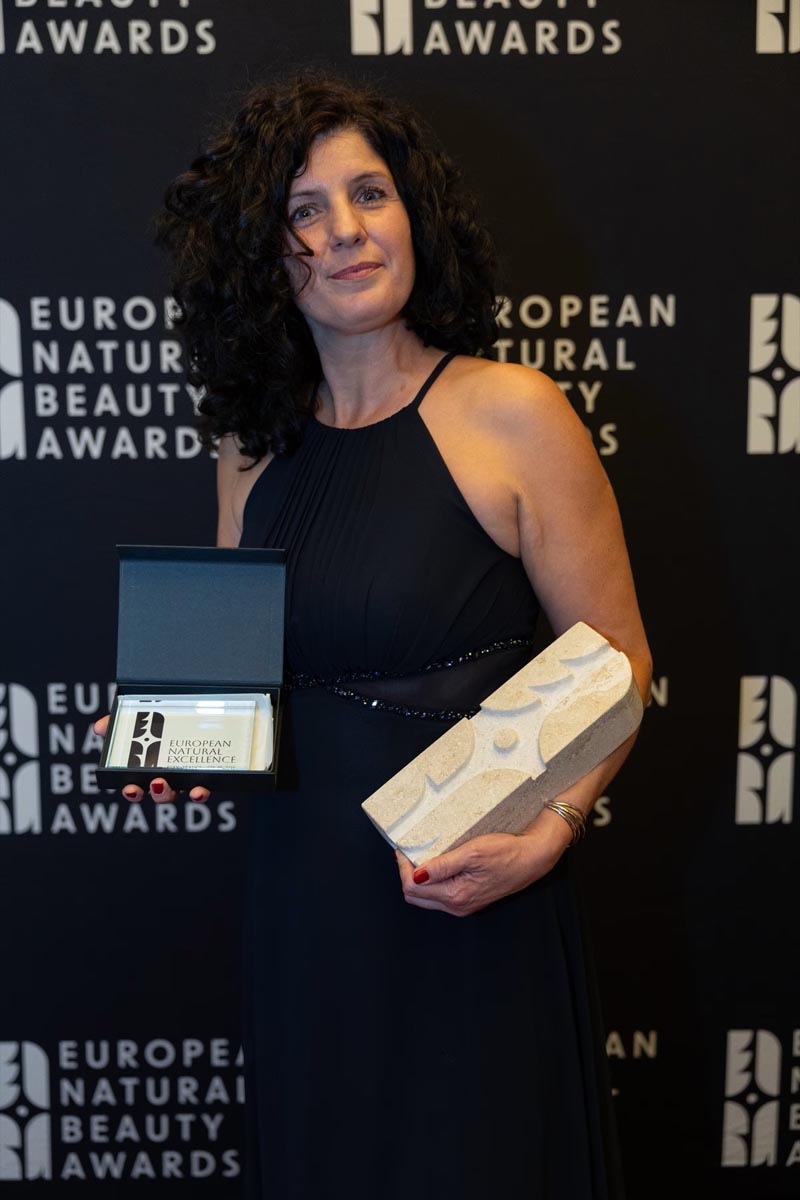 Ivana Ključarić drži priznanje European Natural Beauty Awards ispred brendiranog crnog zida