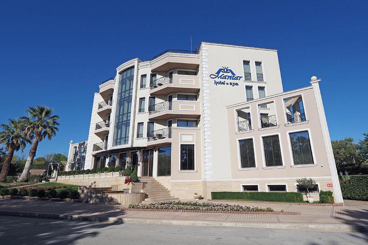 Pročelje luksuznog hotela Mantar Hotel i Spa s palmama i uređenim ulazom pod plavim nebom
