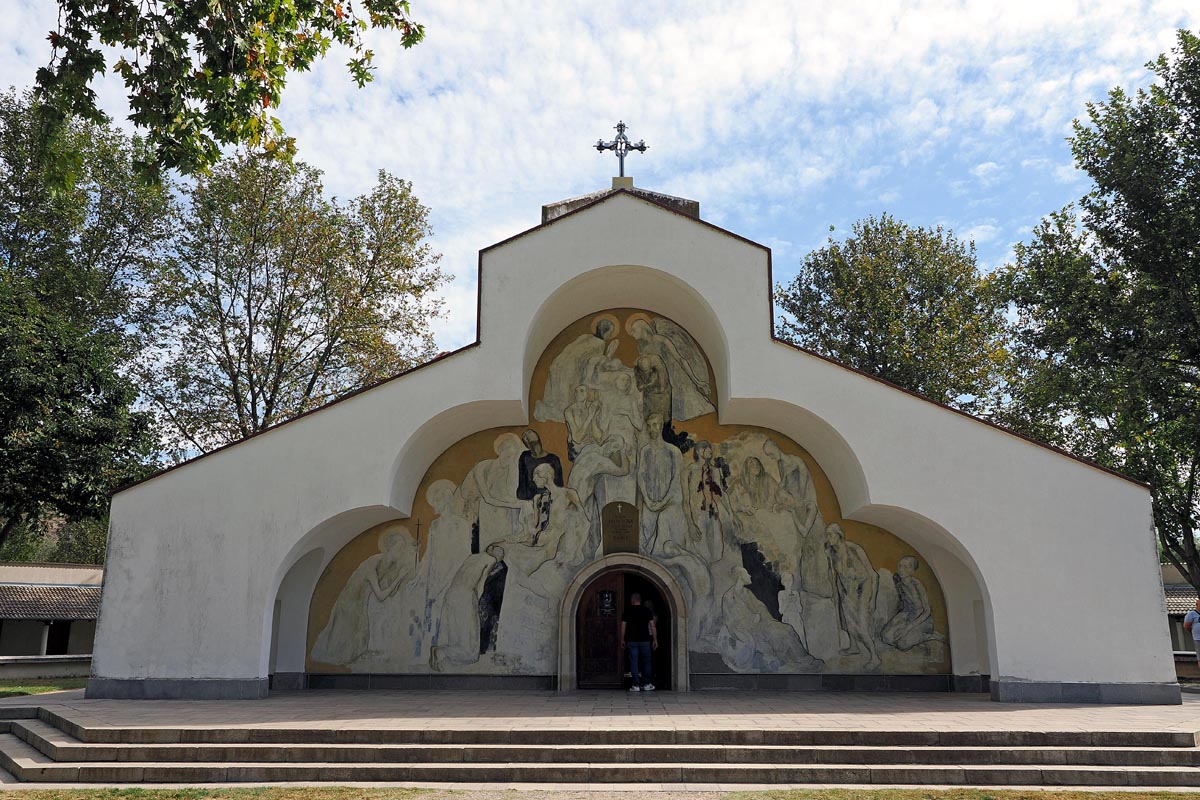 Pročelje crkve Svete Petke u Rupitama s prepoznatljivom velikom freskom iznad ulaza i križem na vrhu