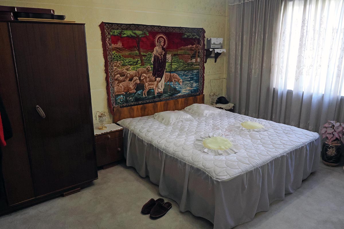 Spavaća soba Babe Vange s velikim tkani ćilimom Isusa Dobrog Pastira iznad kreveta i starim ormarom