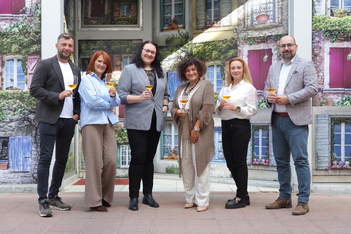 Komisija u sastavu Grozdanović, Šimić, Ivić, Vukelić, Pichler i Prijić s čašama vina ispred kulise