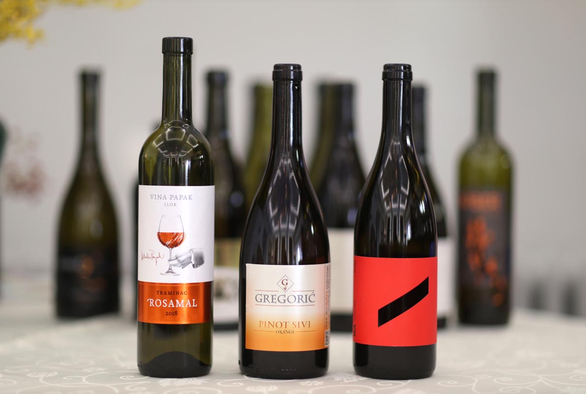 Boce vina Papak Traminac Rosamal, Gregorić Pinot Sivi Orange i Red 2020 Voštinić Klasnić na stolu