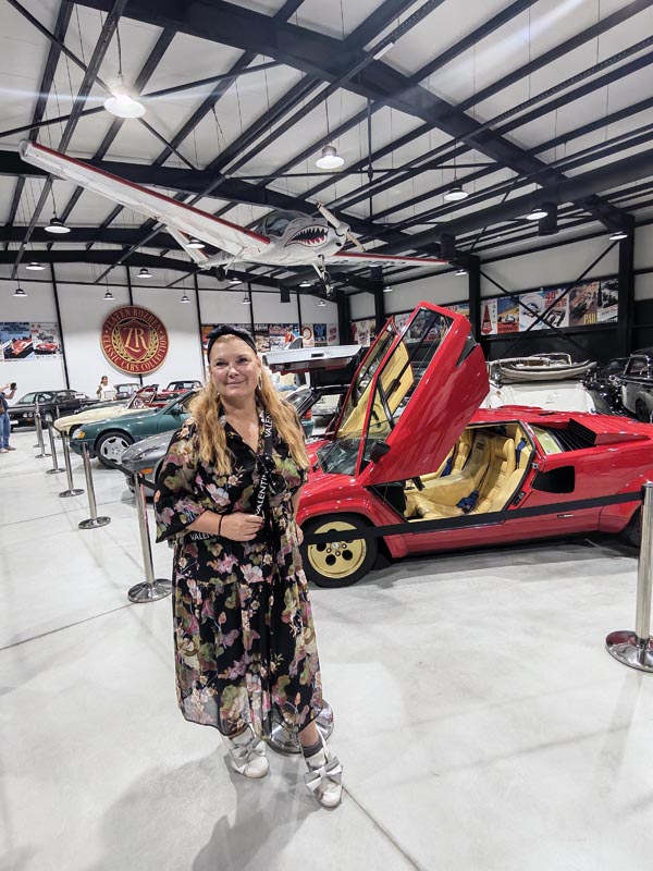 Alma Premerl Zoko pozira uz crveni Lamborghini Countach u Retro Car Museumu Zlaten Rozhen s avionom obješenim o strop dvorane