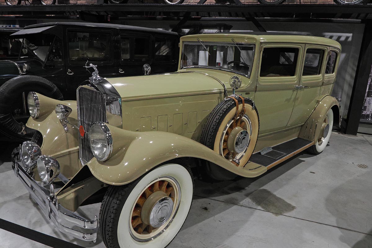 Luksuzni oldtimer Pierce-Arrow bež boje s kromiranim detaljima i bijelim rubovima guma u muzeju