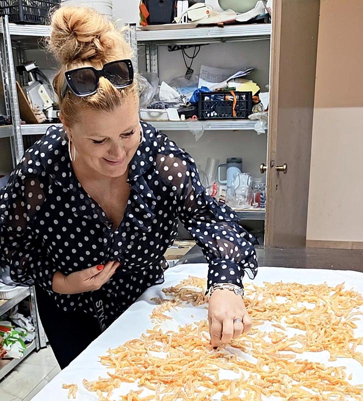 Alma Premerl Zoko s podignutom kosom i sunčanim naočalama slaže domaće arancine na stol