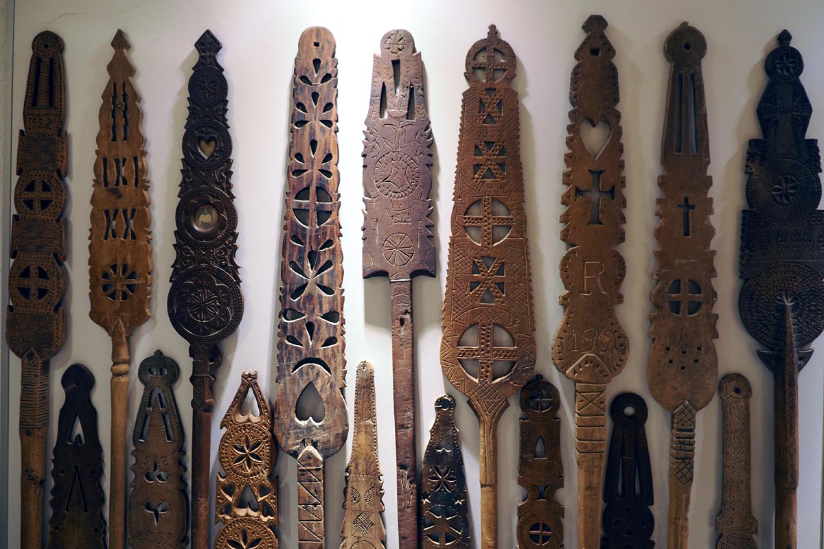 Kolekcija starinskih drvenih preslica s bogatim geometrijskim ornamentima u Etno kući Ilić u Vidu
