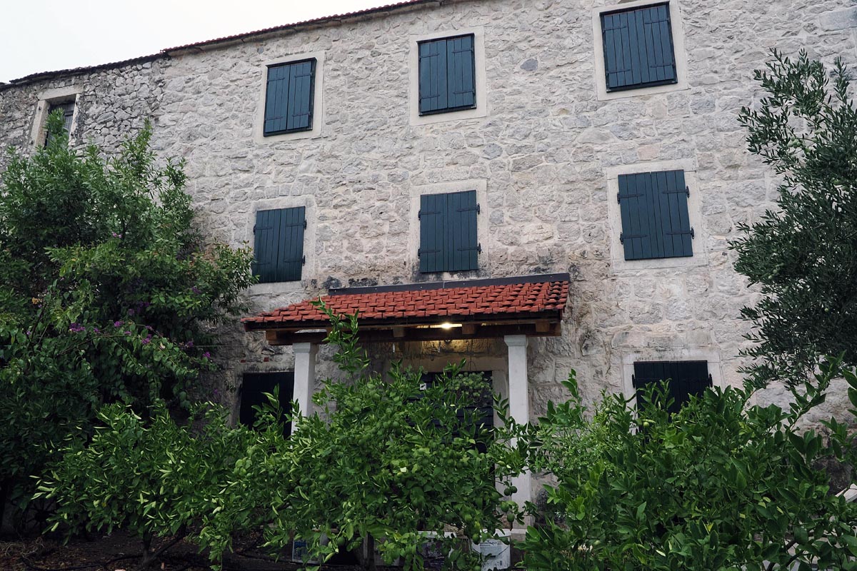 Tradicionalna Etno kuća Ilić u Vidu s kamenom fasadom, zelenim škurama i nasadima agruma ispred ulaza
