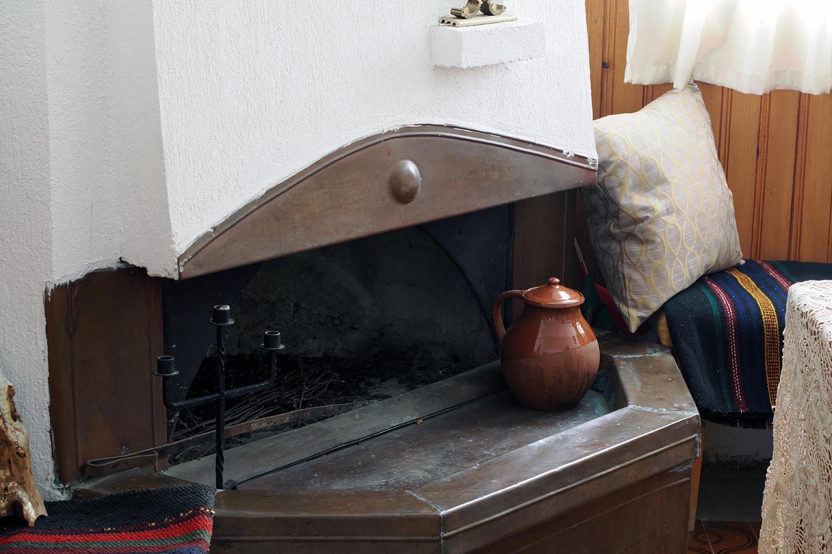 Starinski otvoreni kamin s glinenim vrčem u unutrašnjosti spomen kuće Baba Vange, Rupite