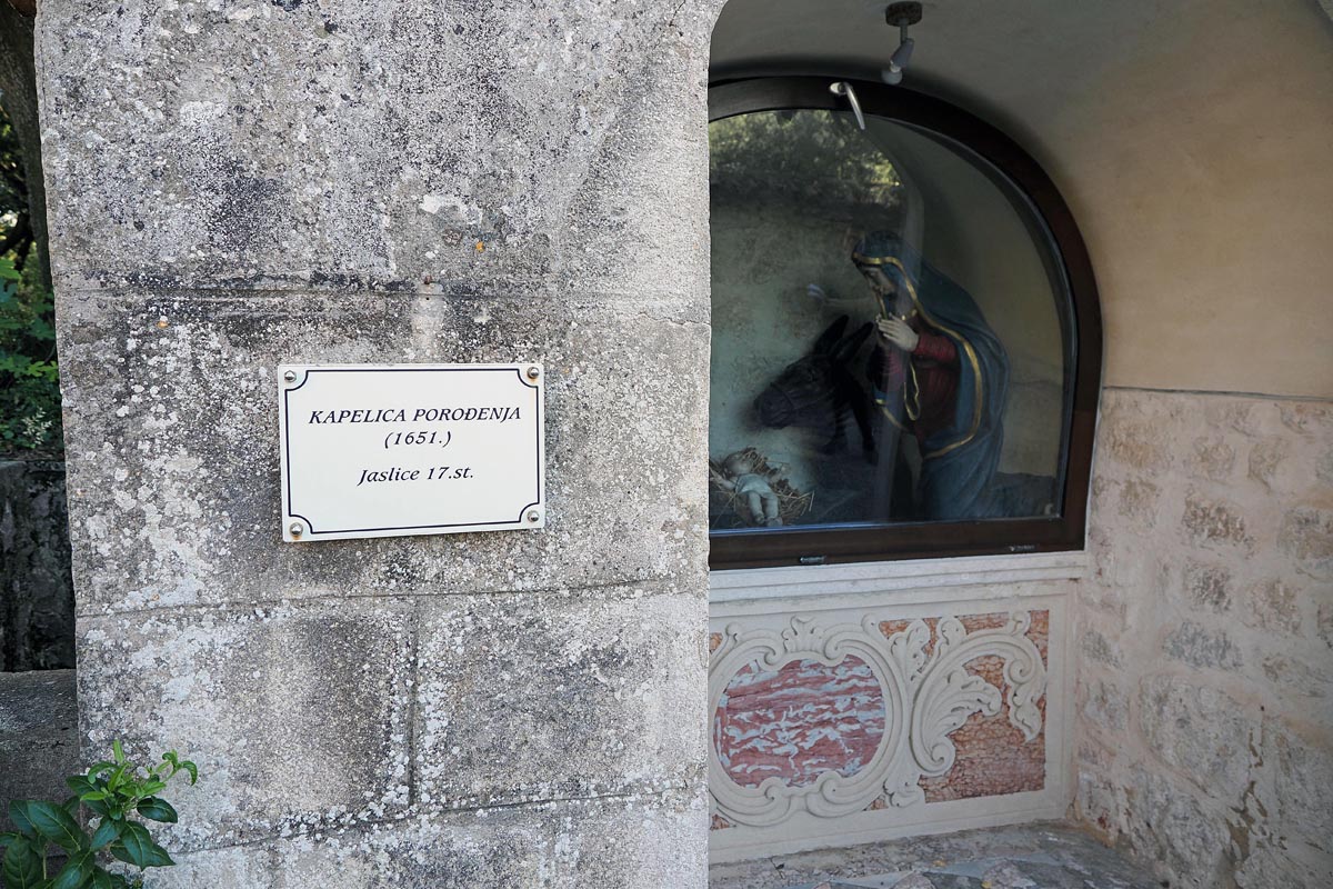 Kamena Kapelica Porođenja iz 1651. godine s povijesnim jaslicama iza stakla na otočiću Košljunu