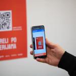 Pametni telefon skenira QR kod na crvenom plakatu za 10. Reli po galerijama