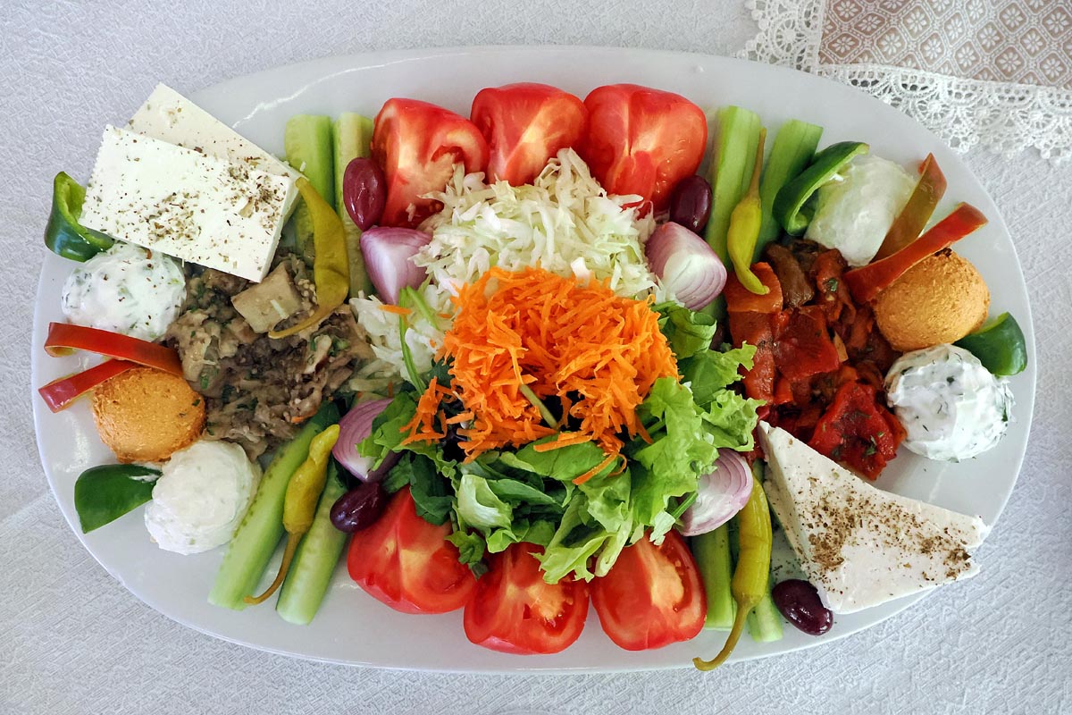 Bogati grčki meze s feta sirom, rajčicama, krastavcima, maslinama i umacima na ovalu