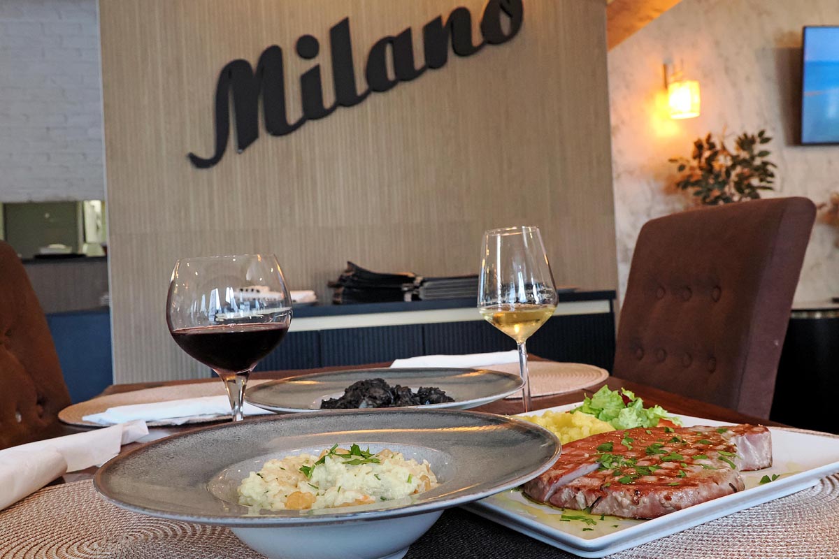 Rižoto, tuna odrezak s prilogom te čaše crnog i bijelog vina na stolu u restoranu Milano u Metkoviću