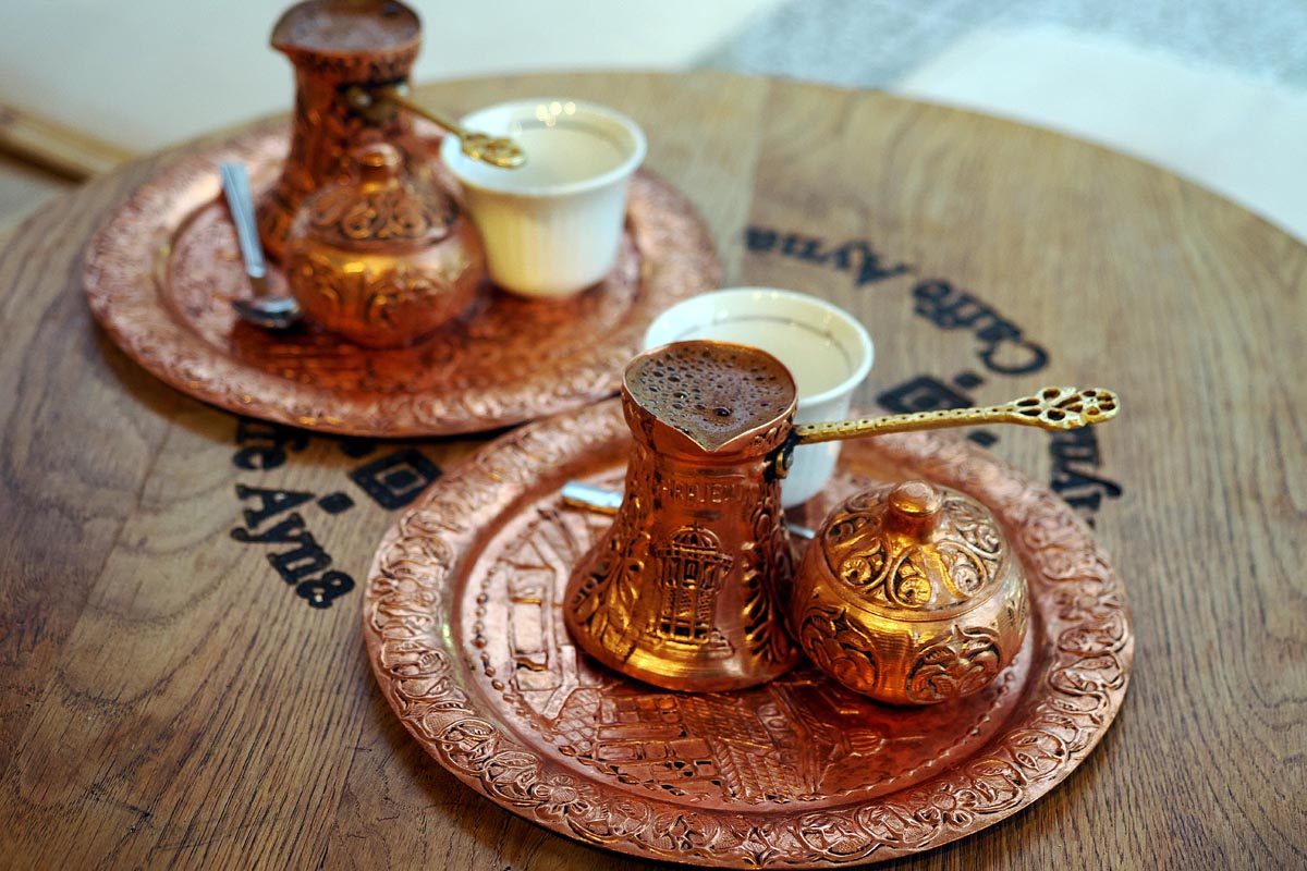 Tradicionalna bosanska kava u bakrenim džezvama na drvenom stolu u kafiću Caffe Ayna