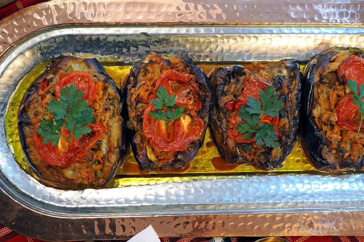 Punjeni patlidžani (karniyarik) s rajčicom i peršinom na duguljastom metalnom pladnju